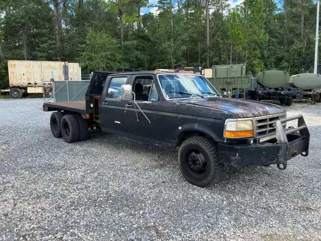 Black flatbed pickup truck at the yard