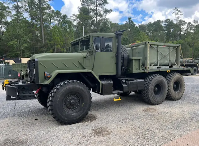 Six-wheel truck with a cargo bed under pine trees