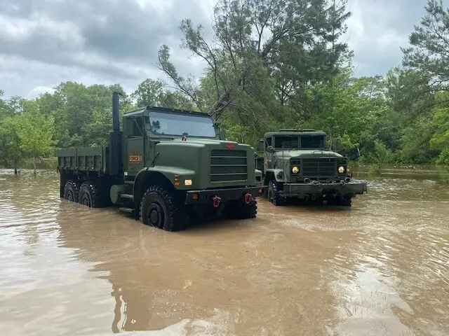 Two trucks driving through flood water
