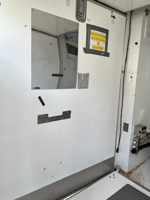 Restroom trailer interior with mirror and fixtures