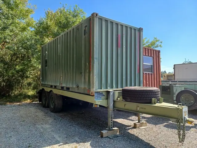 Green shipping container on a trailer at the yard